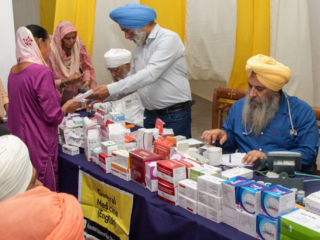 2026-free-medical-camp-bakhshish-international-charitable-society-nussi-jalandhar-04 Physician consulting patients and prescribing medicine at Gurdwara Bakhshish Dham free medical camp 2026