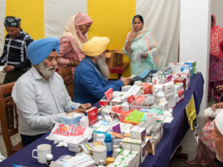 2026-free-medical-camp-bakhshish-international-charitable-society-nussi-jalandhar-05 Physician consulting patients and prescribing medicine at Gurdwara Bakhshish Dham free medical camp 2026